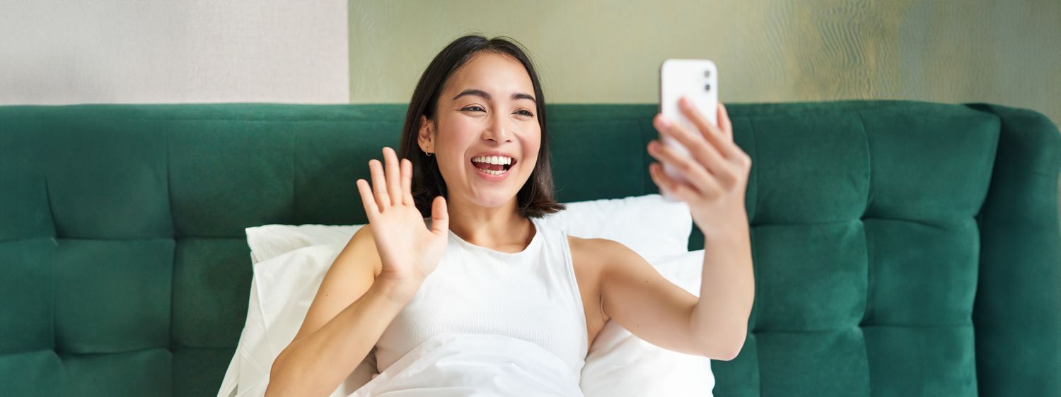 Woman smiling and waving during video call.