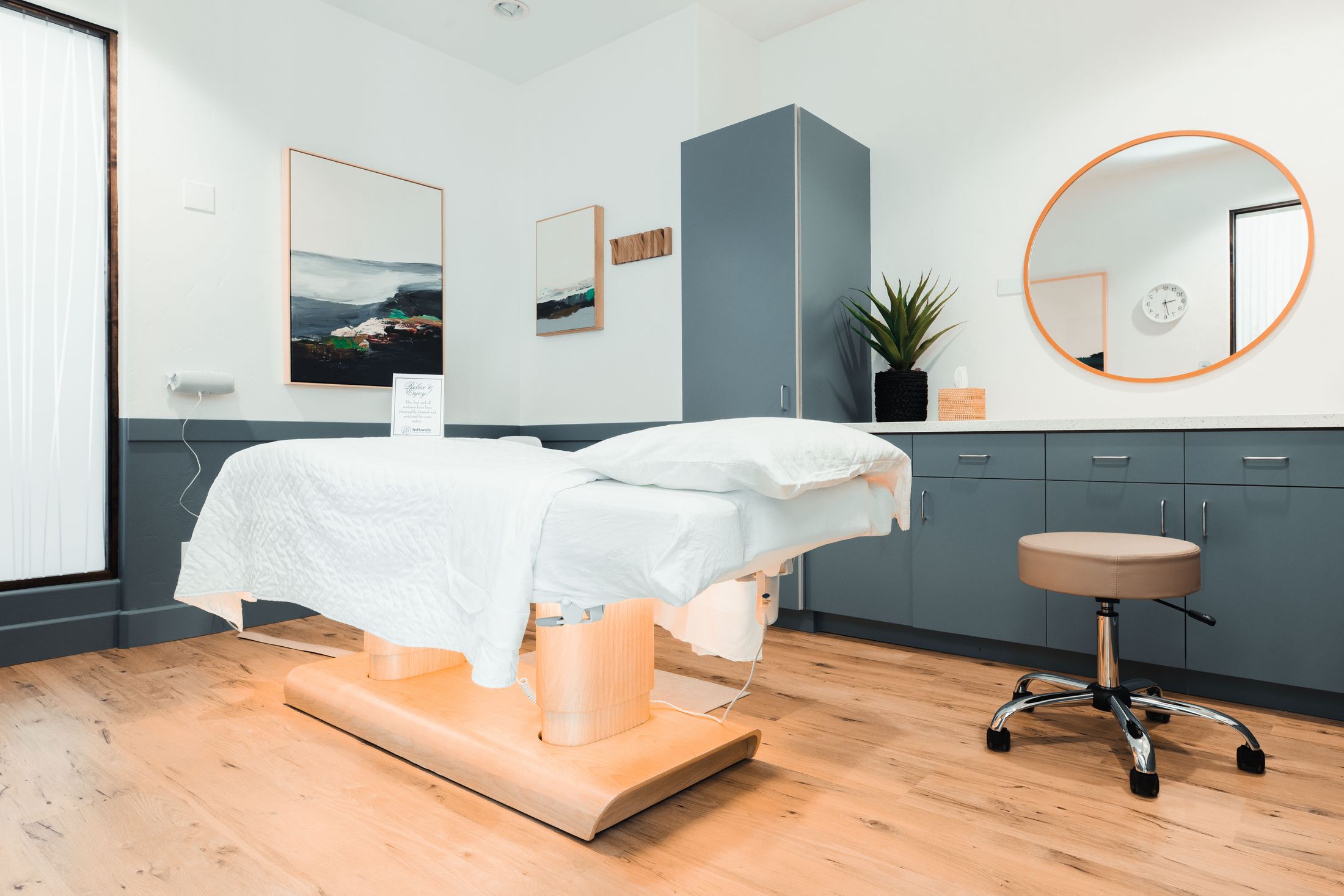 Spa treatment room with massage table and decor.