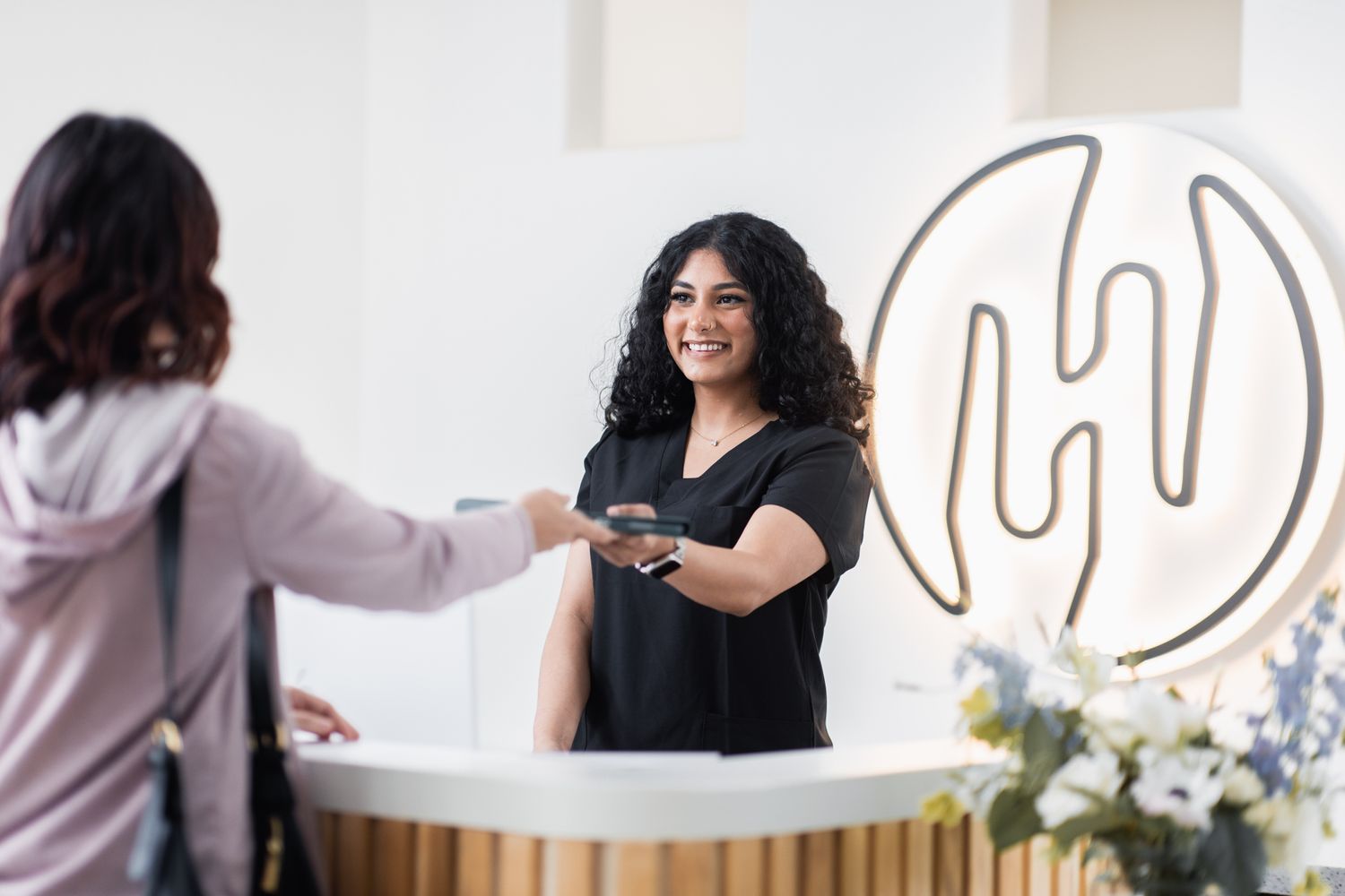 Smiling healthcare professional in green scrubs.