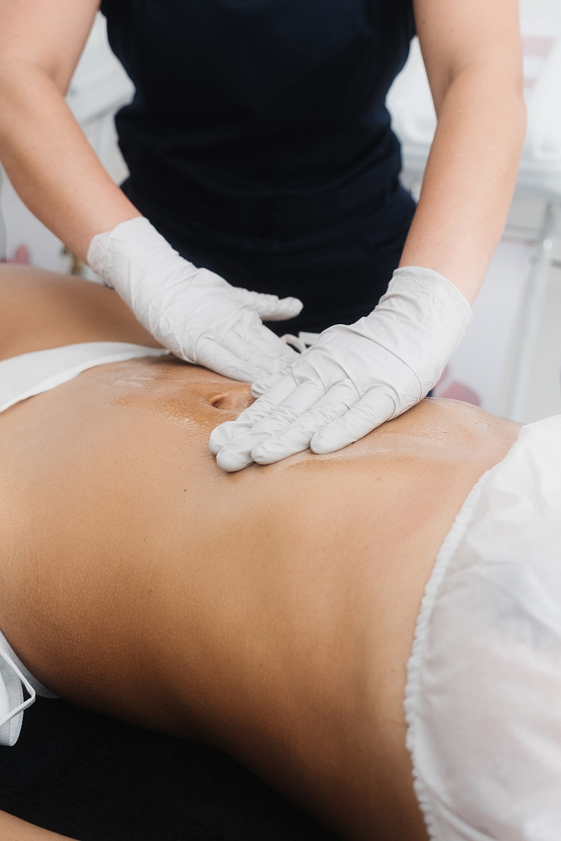 Massage therapy session on a client's abdomen.